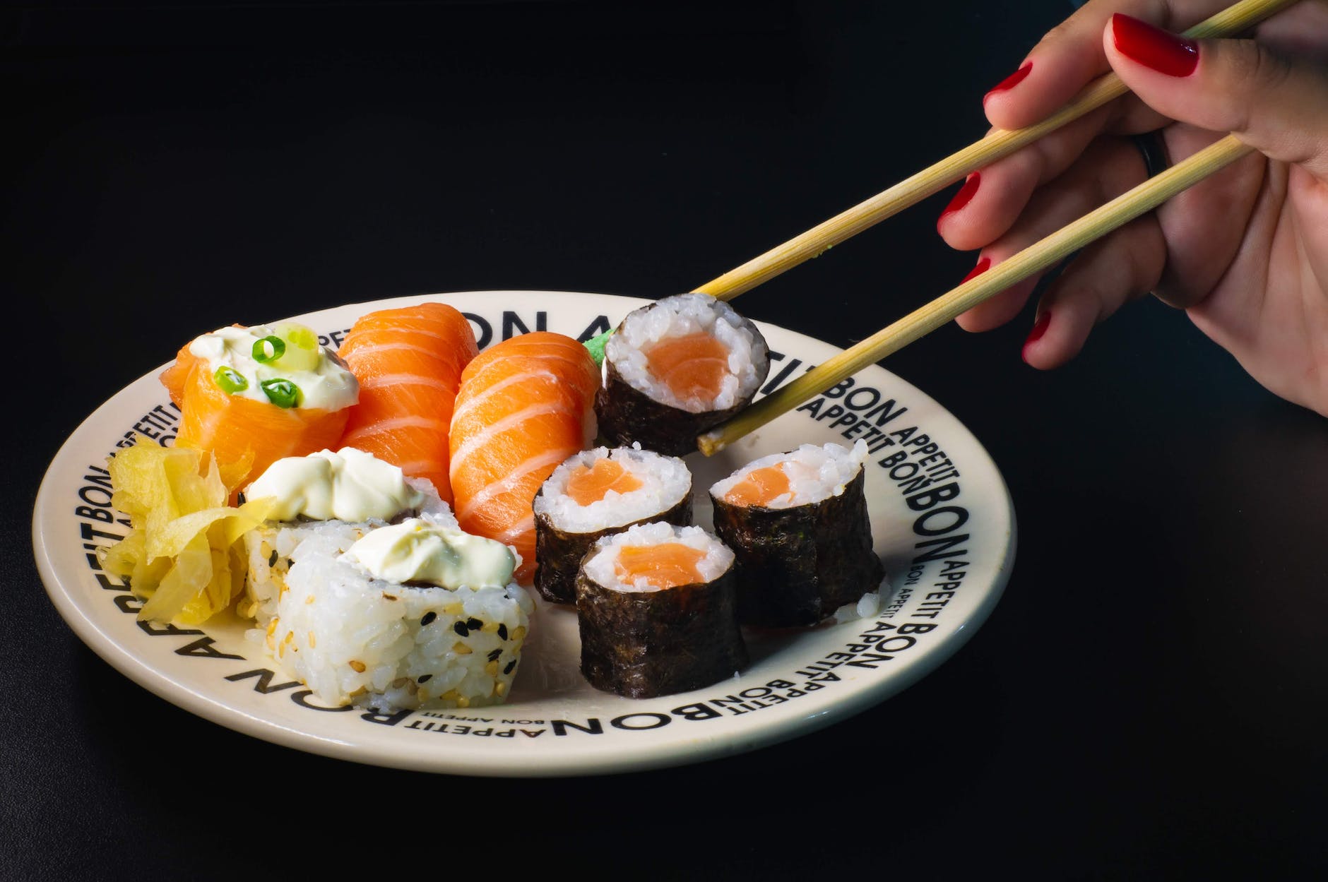 a person holding a delicious maki with a chopsticks