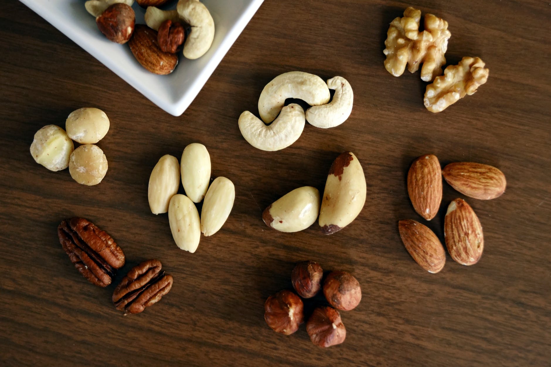 variety of brown nuts on brown wooden panel high angle photo