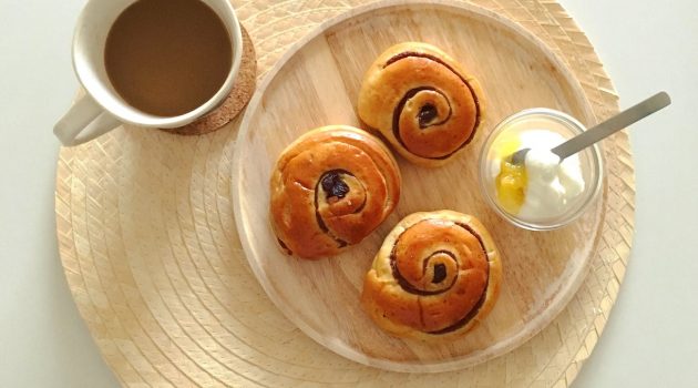 cup of coffee with breads and yogurt on wooden plate