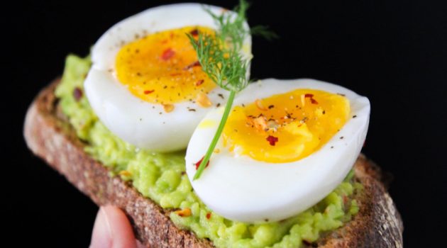 sliced egg on top of green salad with bread