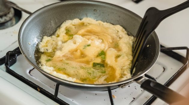 a person cooking scrambled eggs