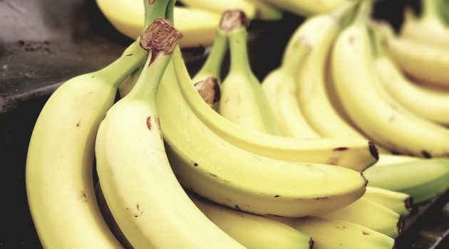 selective focus photo of bunch of bananas on black surface