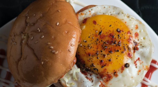 burger with sunny side up on white surface