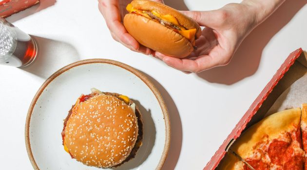 person holding a cheeseburger