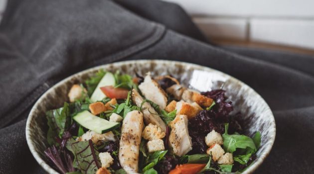 caesar salad presented on plate on gray fabric